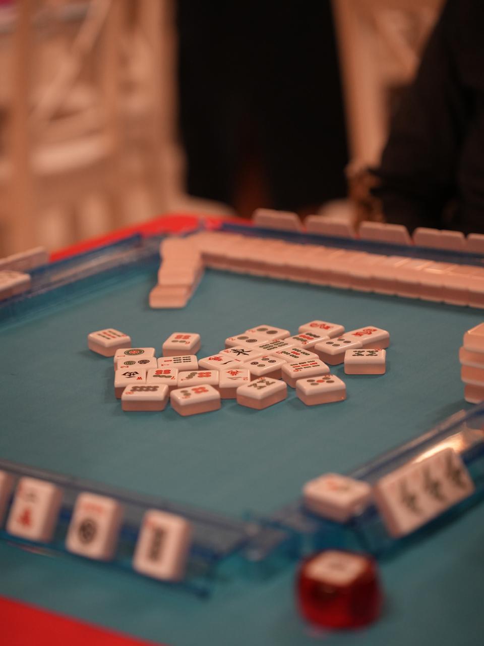 Friends playing Mahjong around a table at Fia's Lounge